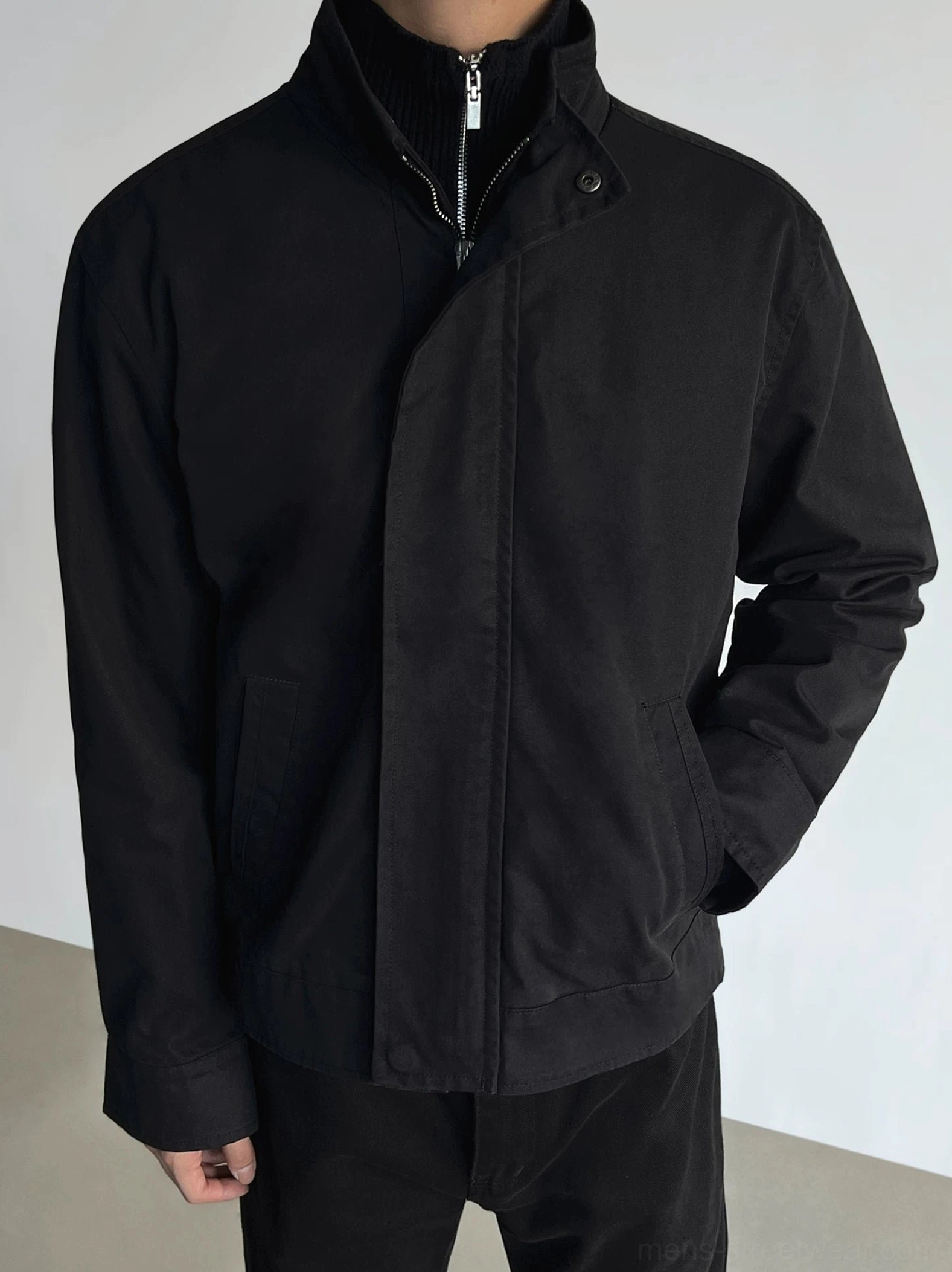Black relaxed fit stand collar zip jacket with side pockets worn by male model for Korean streetwear outfit