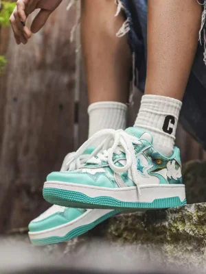 Mint green platform skate sneakers worn with frayed denim shorts and crew socks in an outdoor streetwear styling scene