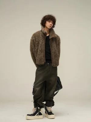 Relaxed fit mocha brown faux shearling cropped jacket shown in a right three-quarter view with dark cargo pants and shoulder bag