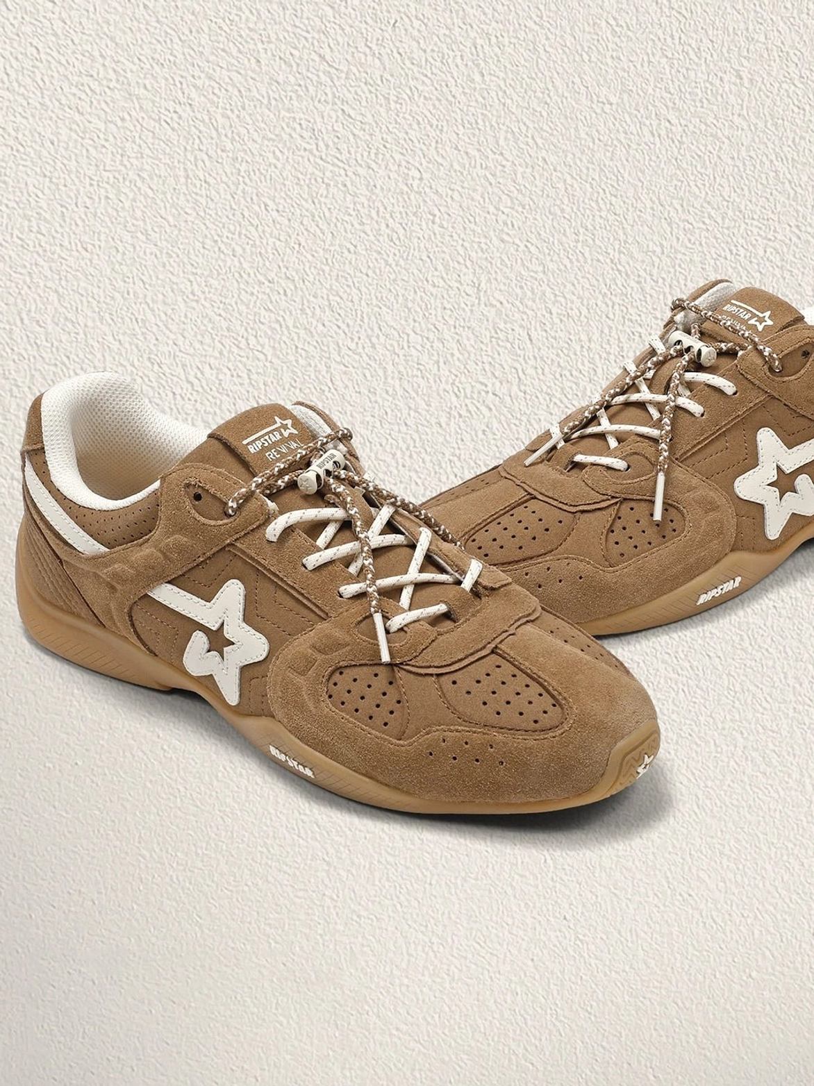 Pair of unisex mocha suede star sneakers displayed on a neutral background with visible retro side panels