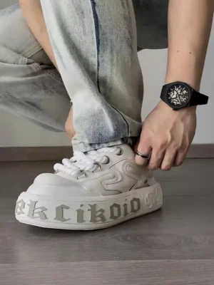 Model wearing chunky white platform skate sneakers with light wash denim jeans in a casual streetwear outfit