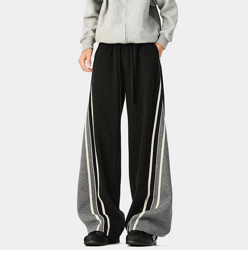 Modern varsity track pants with bold contrast side stripes, extra-long legs, and casual Seoul streetwear styling