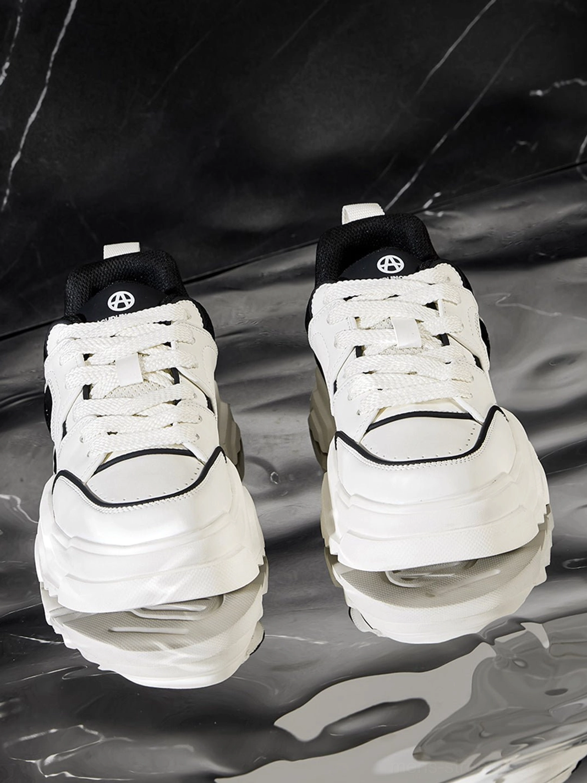 Monochromatic cutout platform sneaker isolated studio detail shot showing textural contrast between synthetic and textile upper materials