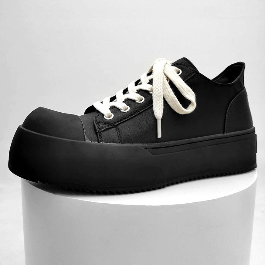 Monochrome all-black chunky platform low-top sneakers displayed from a front three-quarter angle with black laces and serrated black thick sole
