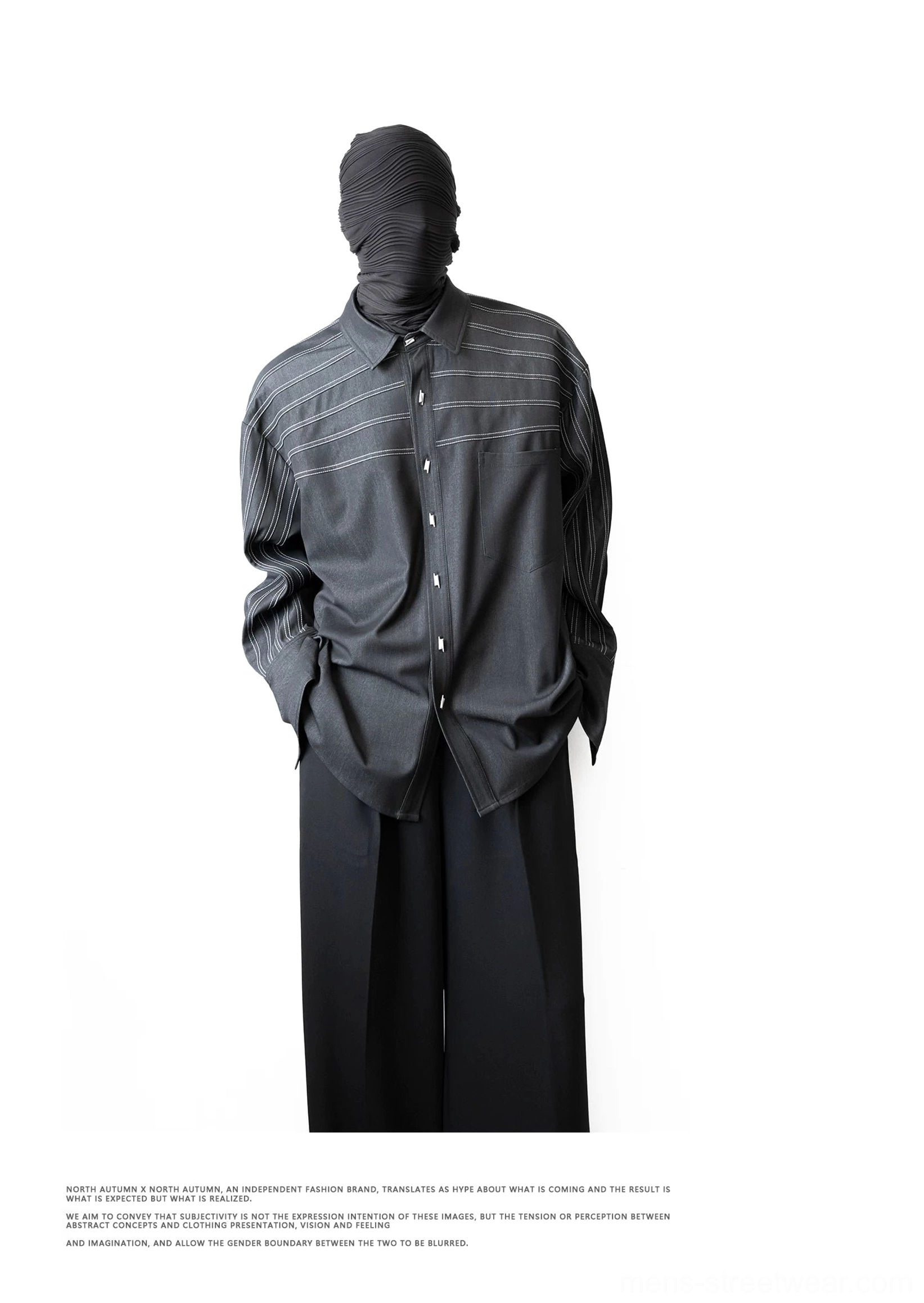 Monochrome styling of a loose black stripe stitch shirt with wide-leg trousers and minimalist urban streetwear proportions