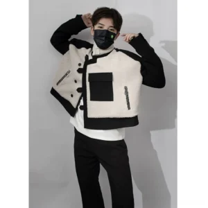 Male model wearing an off white and black cropped sherpa panel streetwear jacket with stand collar and asymmetric frog button closure