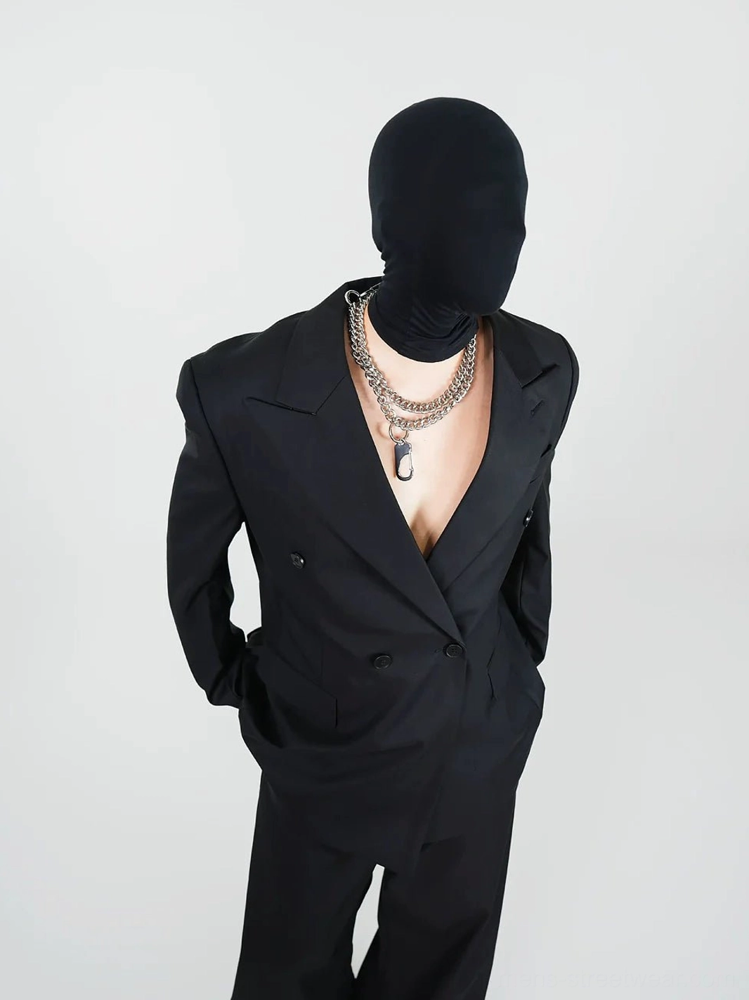 Close-up of black double-breasted blazer with peak lapels flap pocket and structured shoulder tailoring