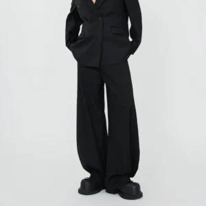 Black draped wide-leg trousers and double-breasted blazer shown from back three-quarter view with platform boots