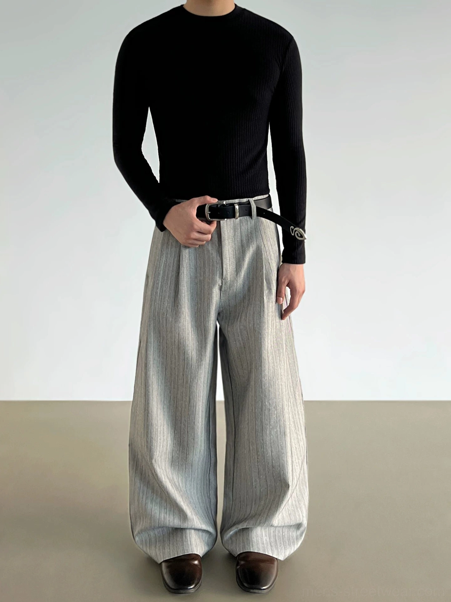 Front view of gray pinstripe wide-leg pleated trousers showing the high-waisted tailored silhouette and relaxed draping legs