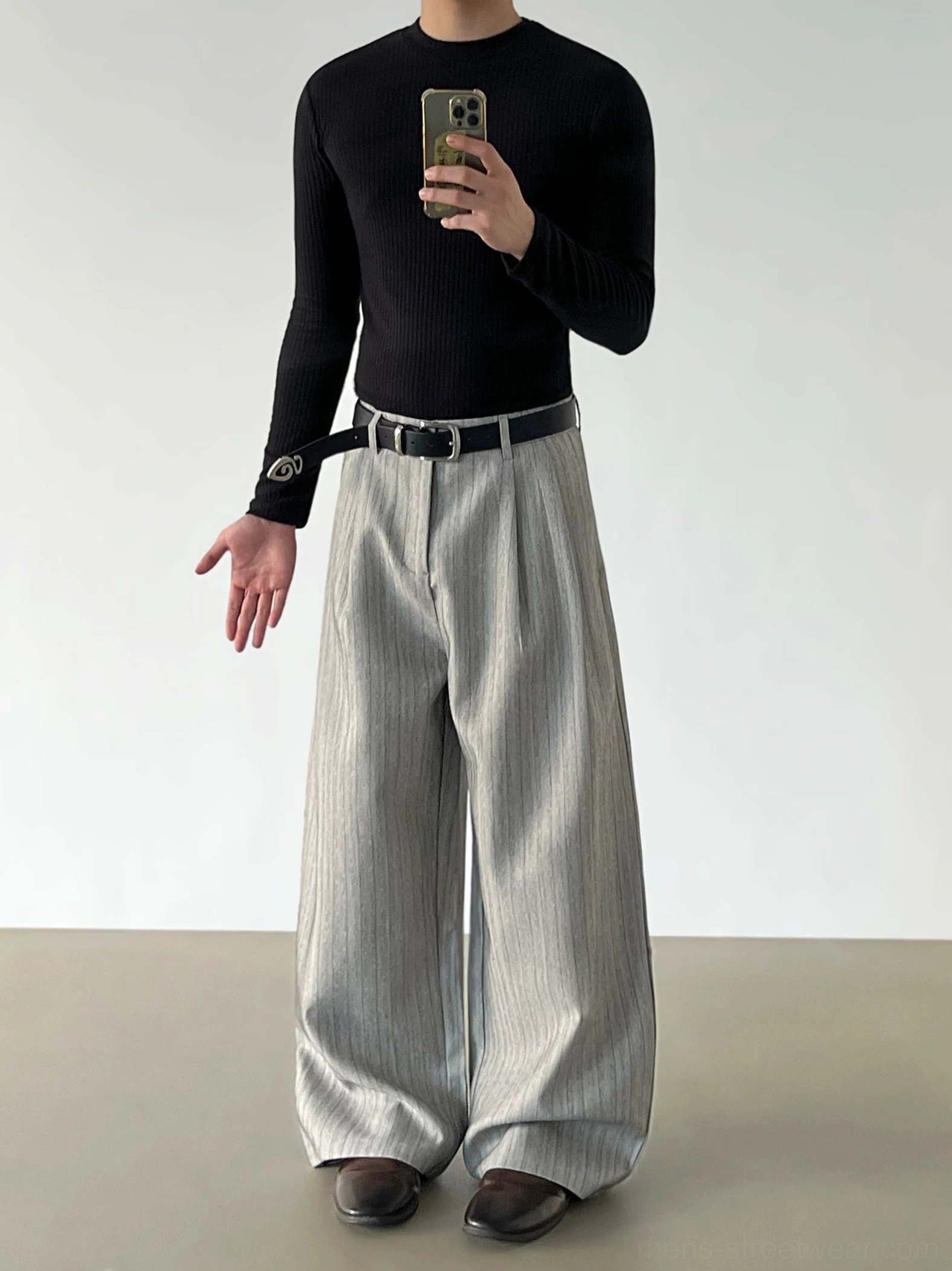Gray pinstripe pleated wide-leg trousers in a mirror styling view with draped legs and decorative buckle belt detail