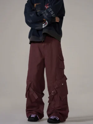 Multi-strap wide-leg cargo pants styled in a burgundy tone with a cropped graphic hoodie for oversized streetwear