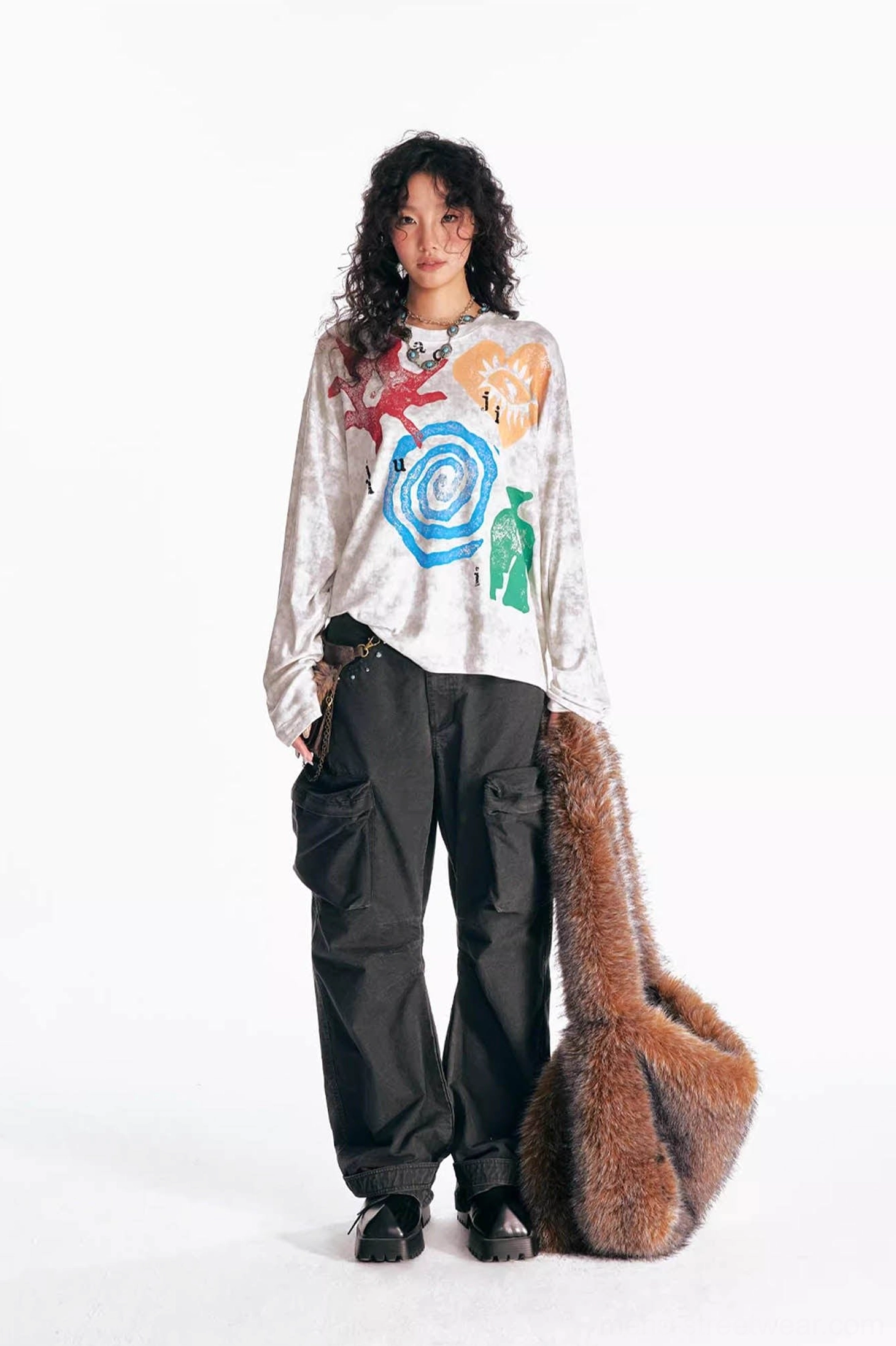 Multicolor washed tribal graphic long sleeve tee styled with black wide-leg cargo pants and furry shoulder bag