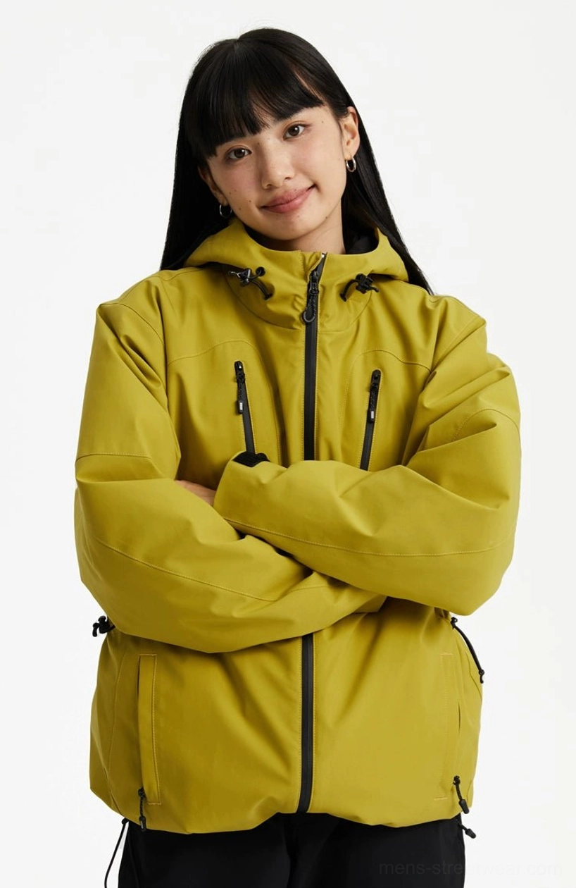 Mustard yellow hooded padded streetwear jacket shown from the front with a center zipper and adjustable drawcord hem