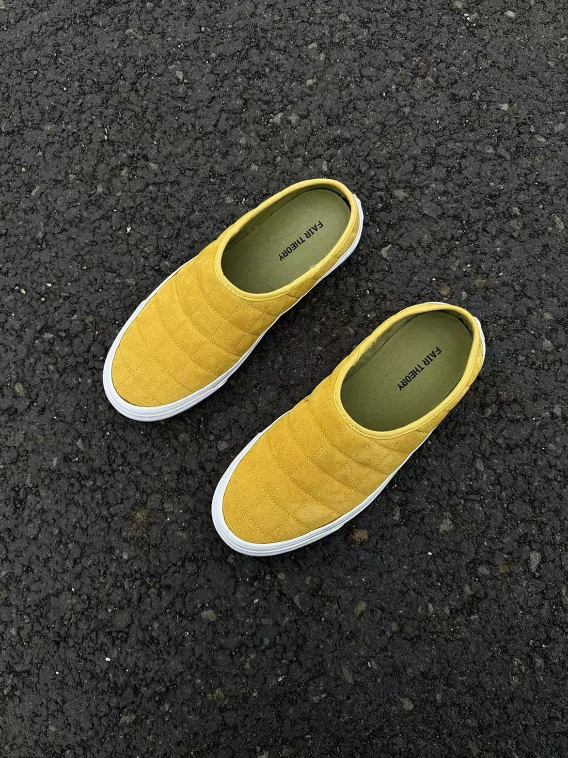 Top view of a pair of mustard yellow quilted backless sneaker mules with diamond stitched uppers