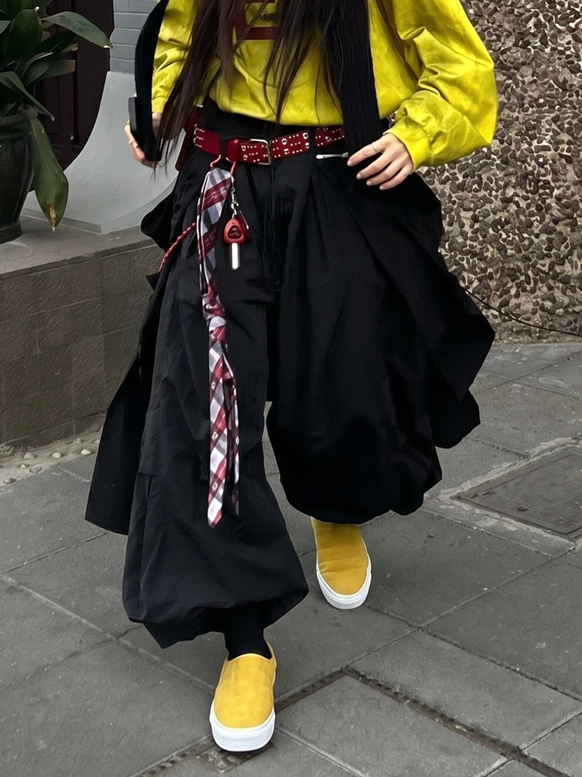 Pair of mustard yellow quilted slip-on sneaker mules worn with colorful Korean-inspired streetwear styling