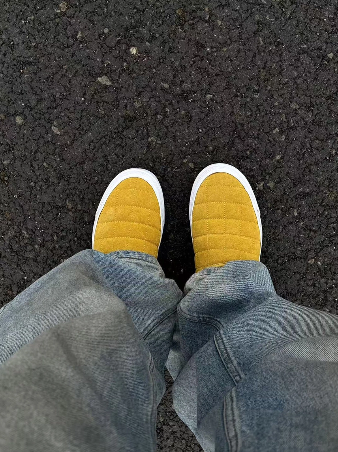 Mustard yellow quilted sneaker mules worn from above showing rounded toe caps and white outsole edges