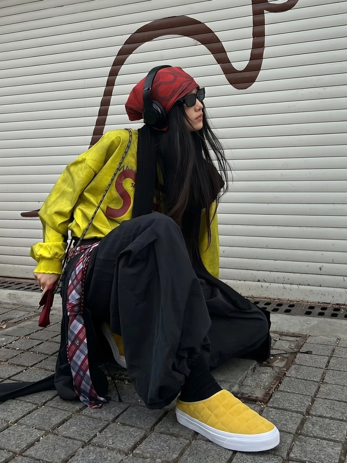 Female model wearing mustard yellow quilted slip-on sneaker mules with a coordinated yellow streetwear outfit
