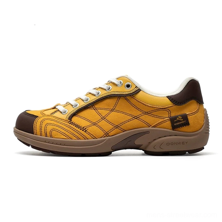 Mustard yellow retro runner sneakers with crisscross canvas stitching, dark brown toe cap and heel tab, and vintage rubber outsole