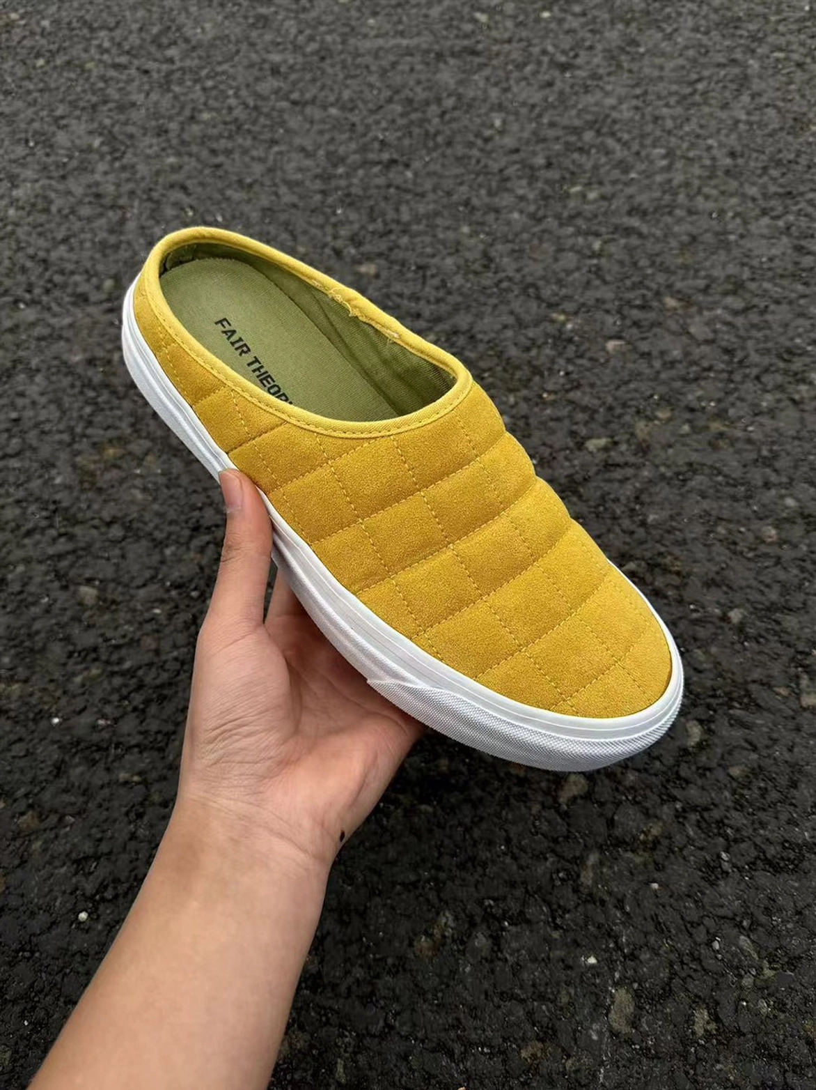 Close-up of mustard yellow rhombus quilted sneaker mule showing padded upper and clean white rubber sole