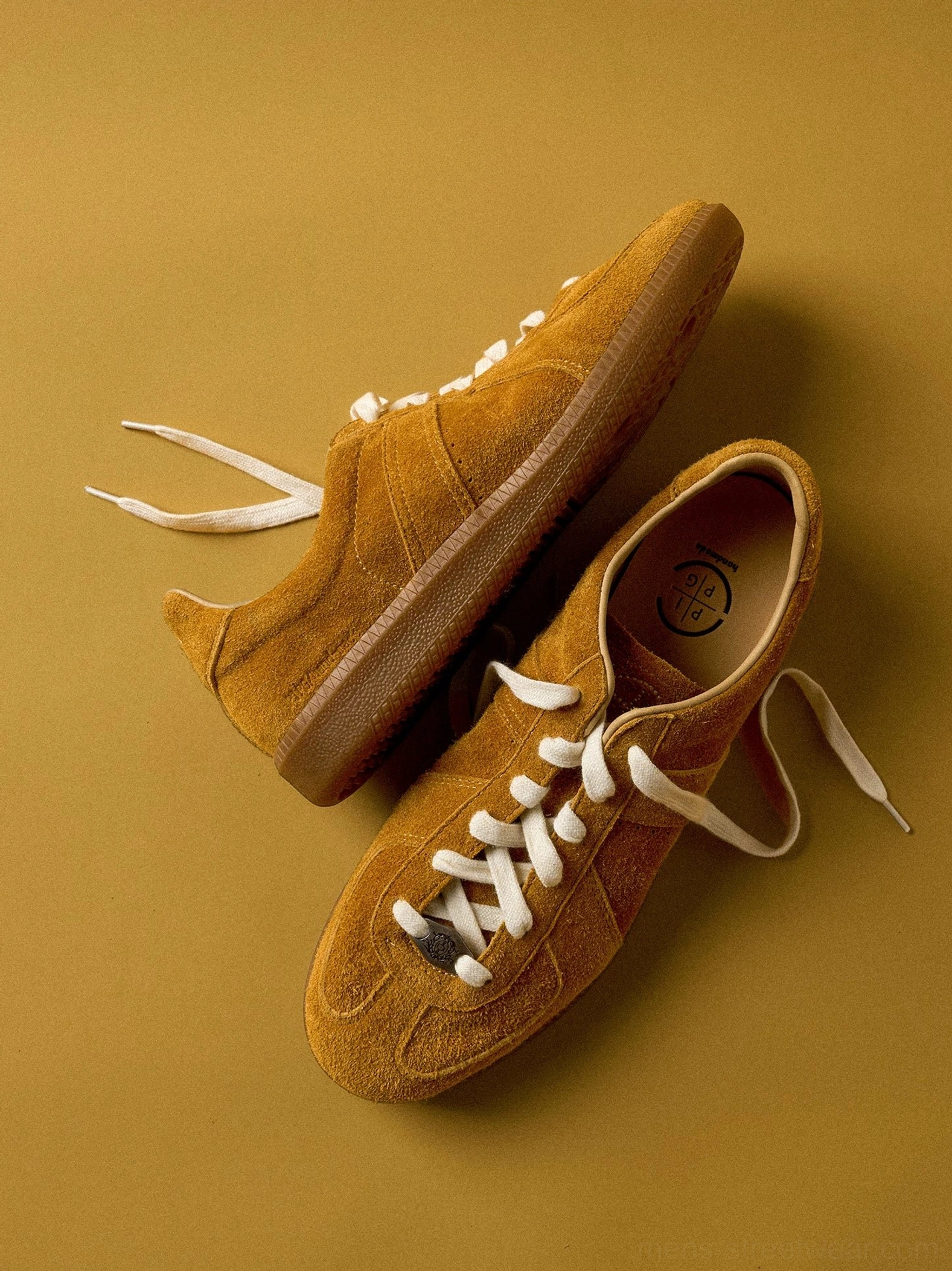 Mustard yellow suede heritage sneakers with classic retro trainer silhouette, cream laces, and gum sole
