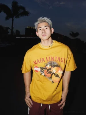 Mustard yellow vintage citrus graphic T-shirt with orange fruit and floral print styled in oversized Korean streetwear fashion