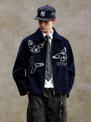 Male model wearing navy bird embroidered textured zip-up streetwear jacket with pointed collar in full front view