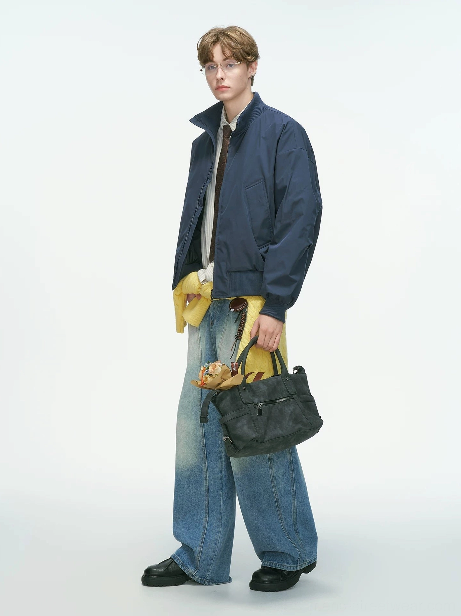 Navy blue bomber jacket full side body shot featuring stand collar and loose silhouette, paired with formal shirt and wide-leg denim streetwear styling