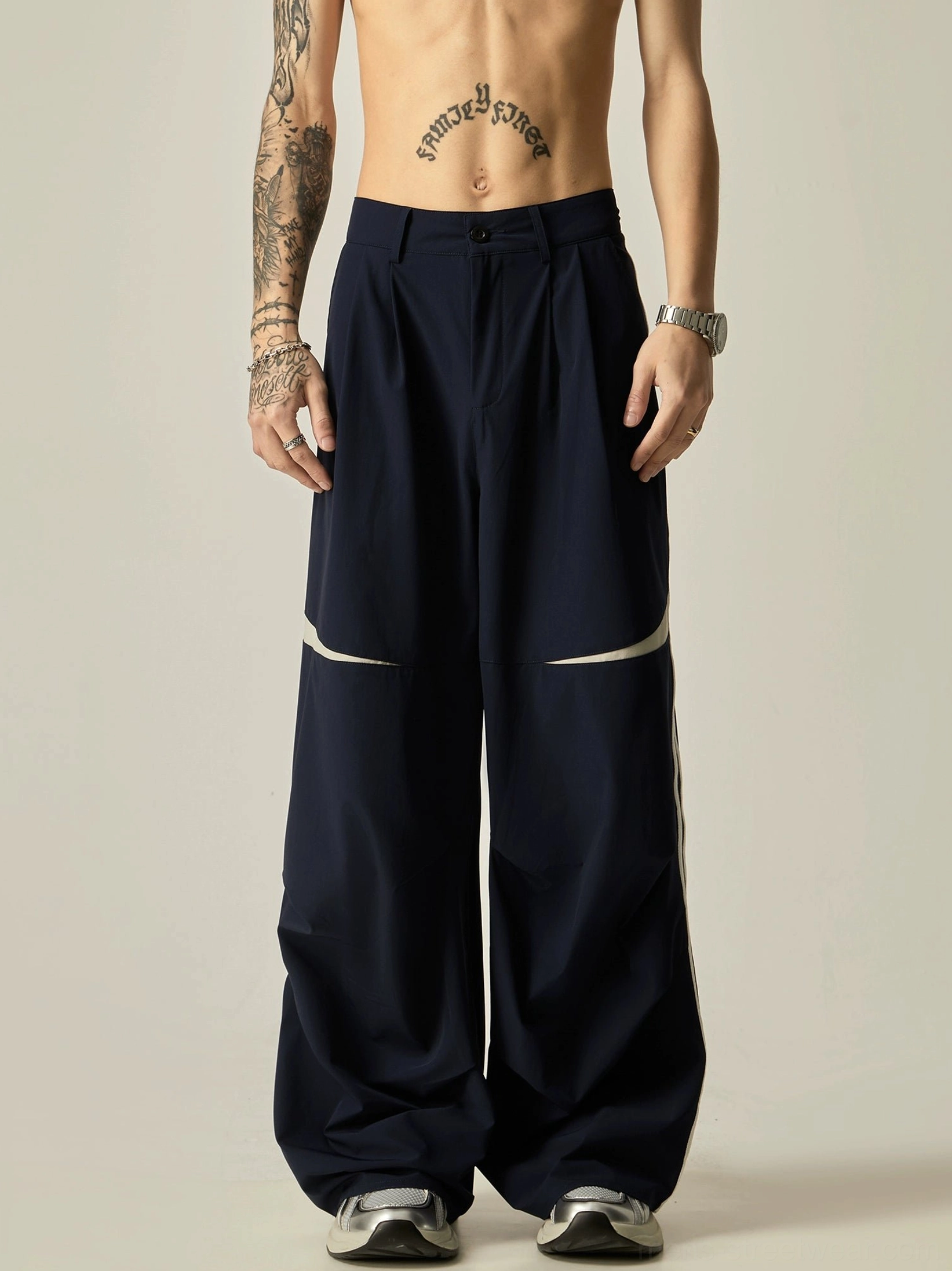 Navy blue wide-leg track pants with double white side stripes, pleated waist, and relaxed baggy Korean streetwear fit