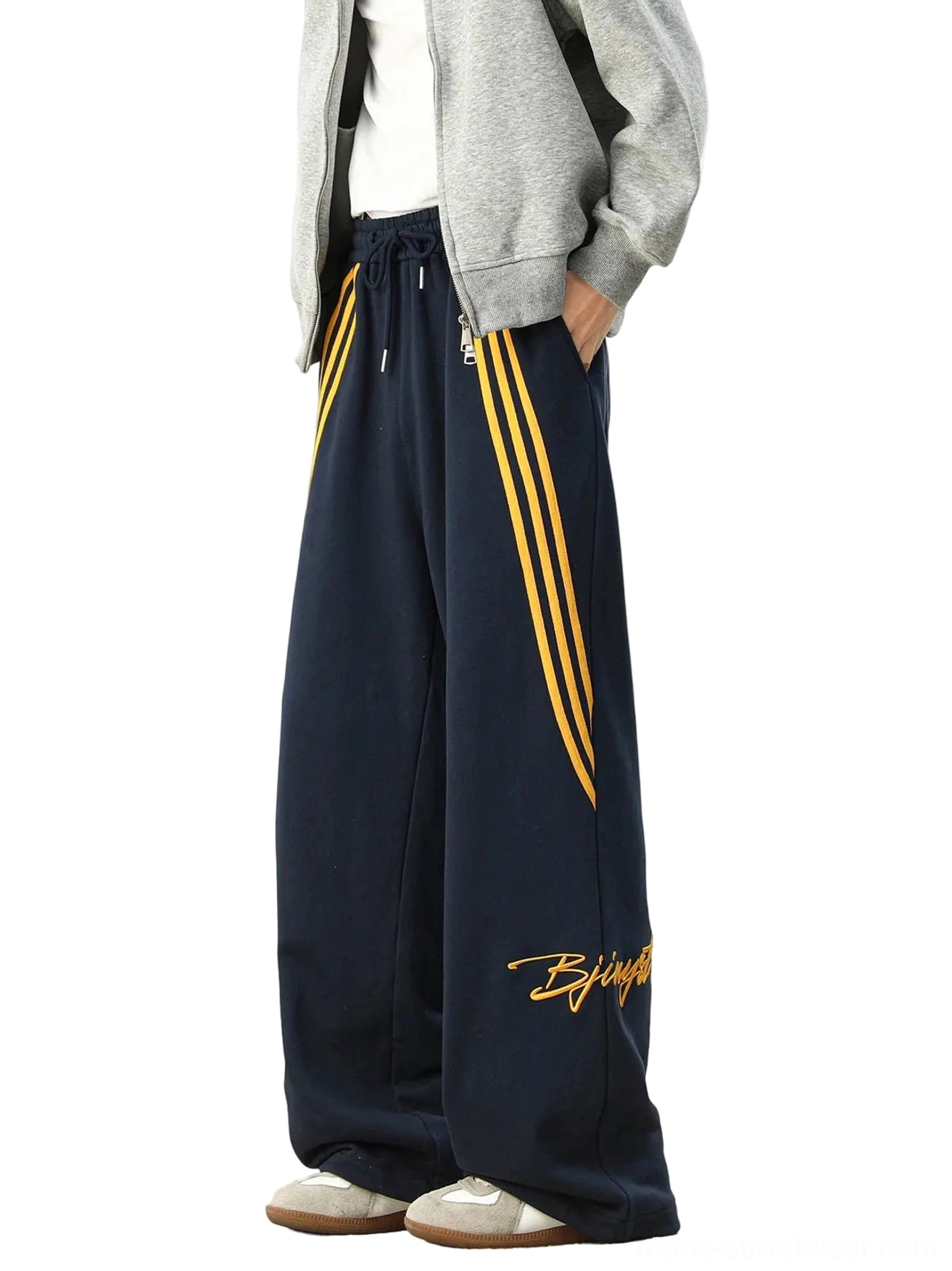 Navy blue oversized striped wide-leg Seoul streetwear sweatpants with golden yellow side stripes, embroidered script detail, elastic drawstring waist, and relaxed sneaker-stacking fit