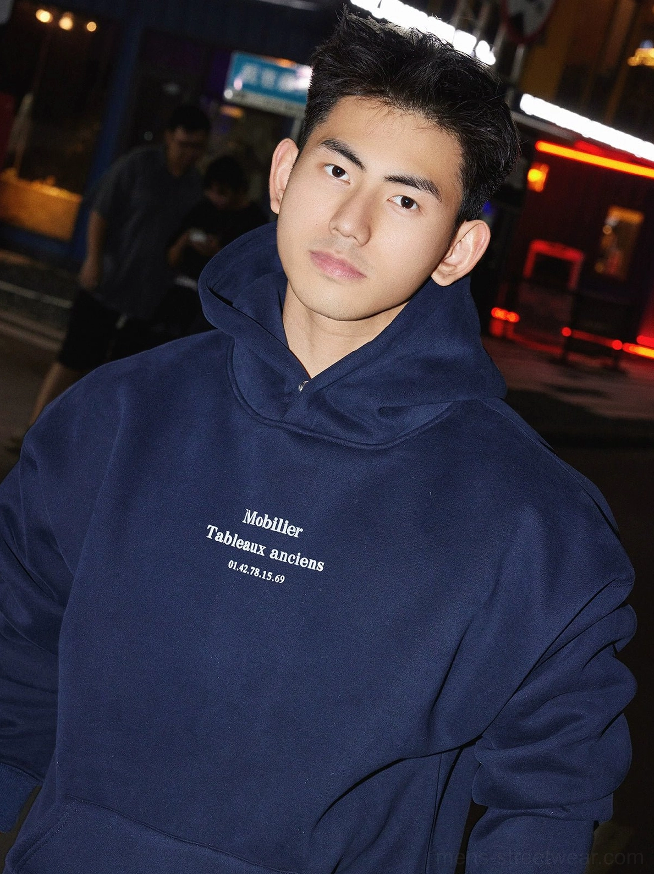Navy blue relaxed pullover hoodie with subtle front lettering and soft fabric texture for contemporary street fashion