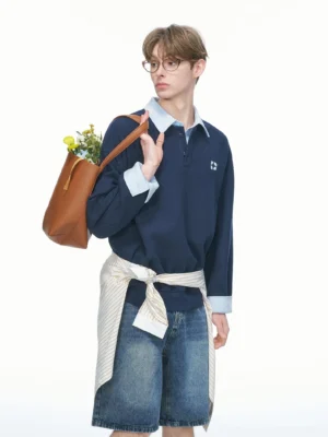 Navy blue varsity collar rugby sweatshirt in a relaxed oversized Korean streetwear fit with contrast collar cuffs quarter-button placket and embroidered chest logo