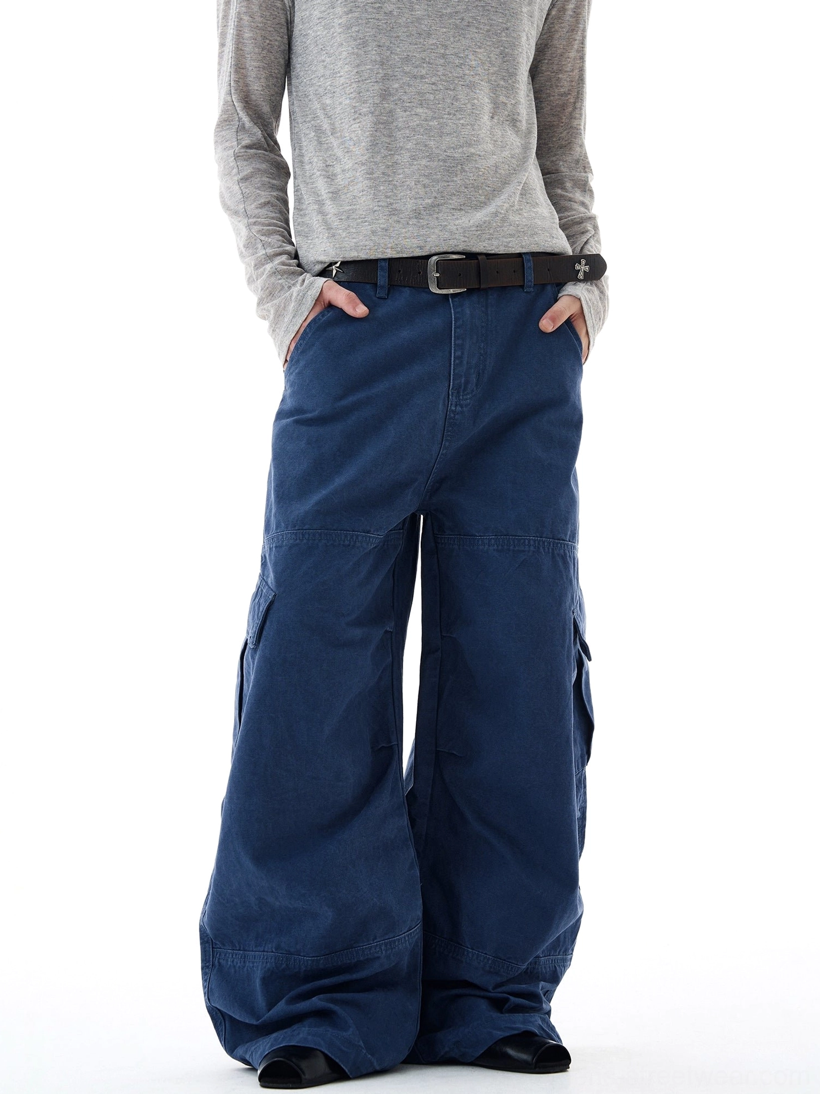 Navy blue wide-leg cargo pants shown from the front with hands in pockets, sturdy cotton twill texture, and relaxed oversized fit