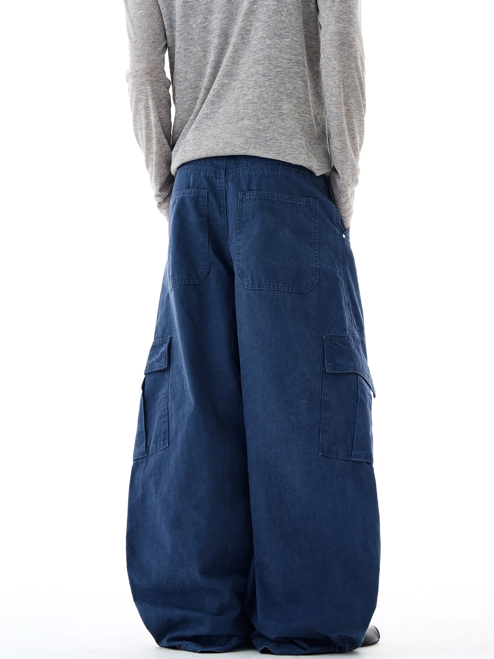 Rear view of navy blue wide-leg cargo pants showing back patch pockets, side cargo pockets, and a loose oversized silhouette