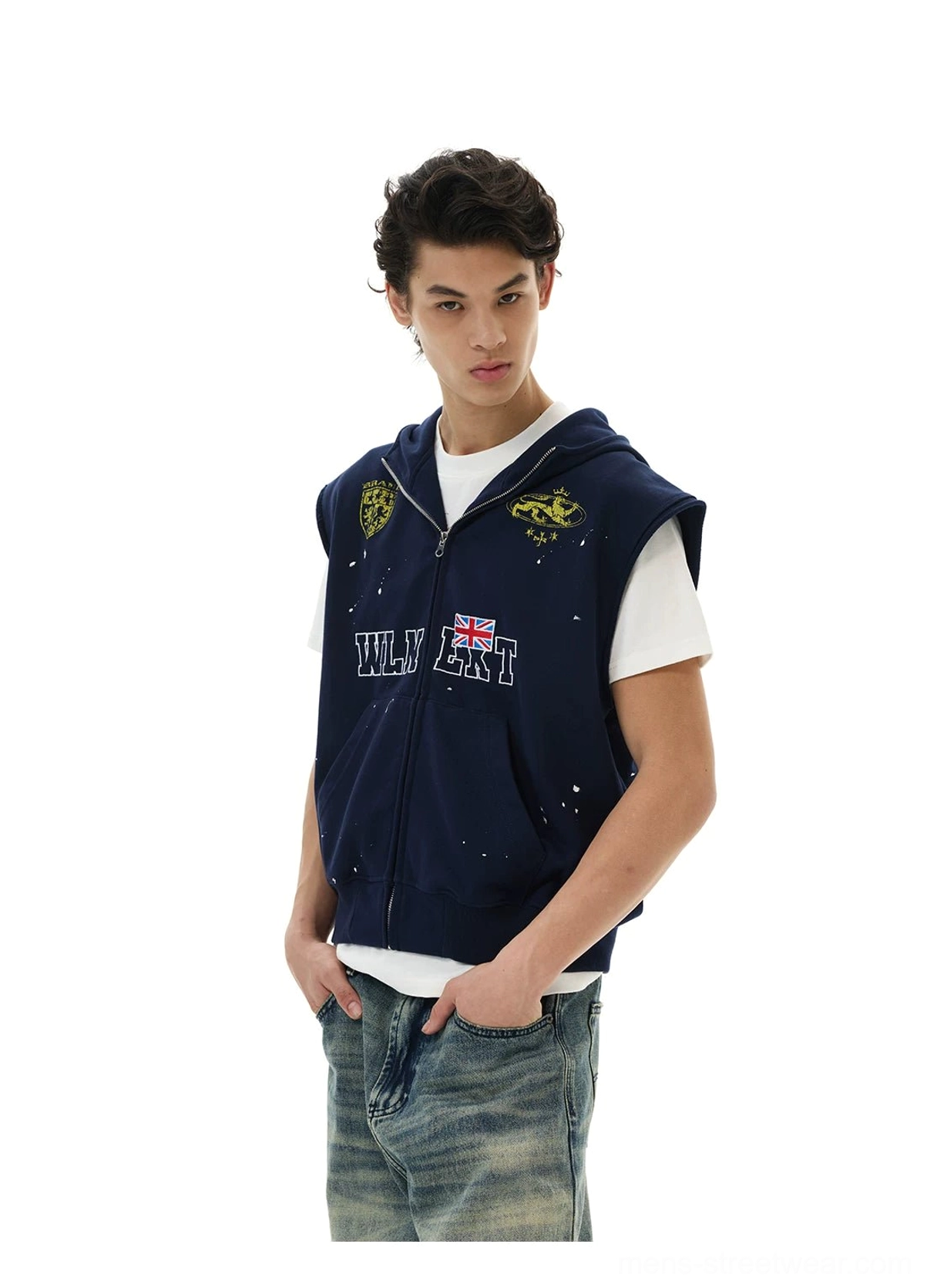 Three quarter view of navy sleeveless zip hoodie vest with crest embroidery style graphics and splatter streetwear details