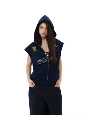 Female model wearing navy collegiate crest sleeveless zip hoodie vest with hood up and dark denim jeans