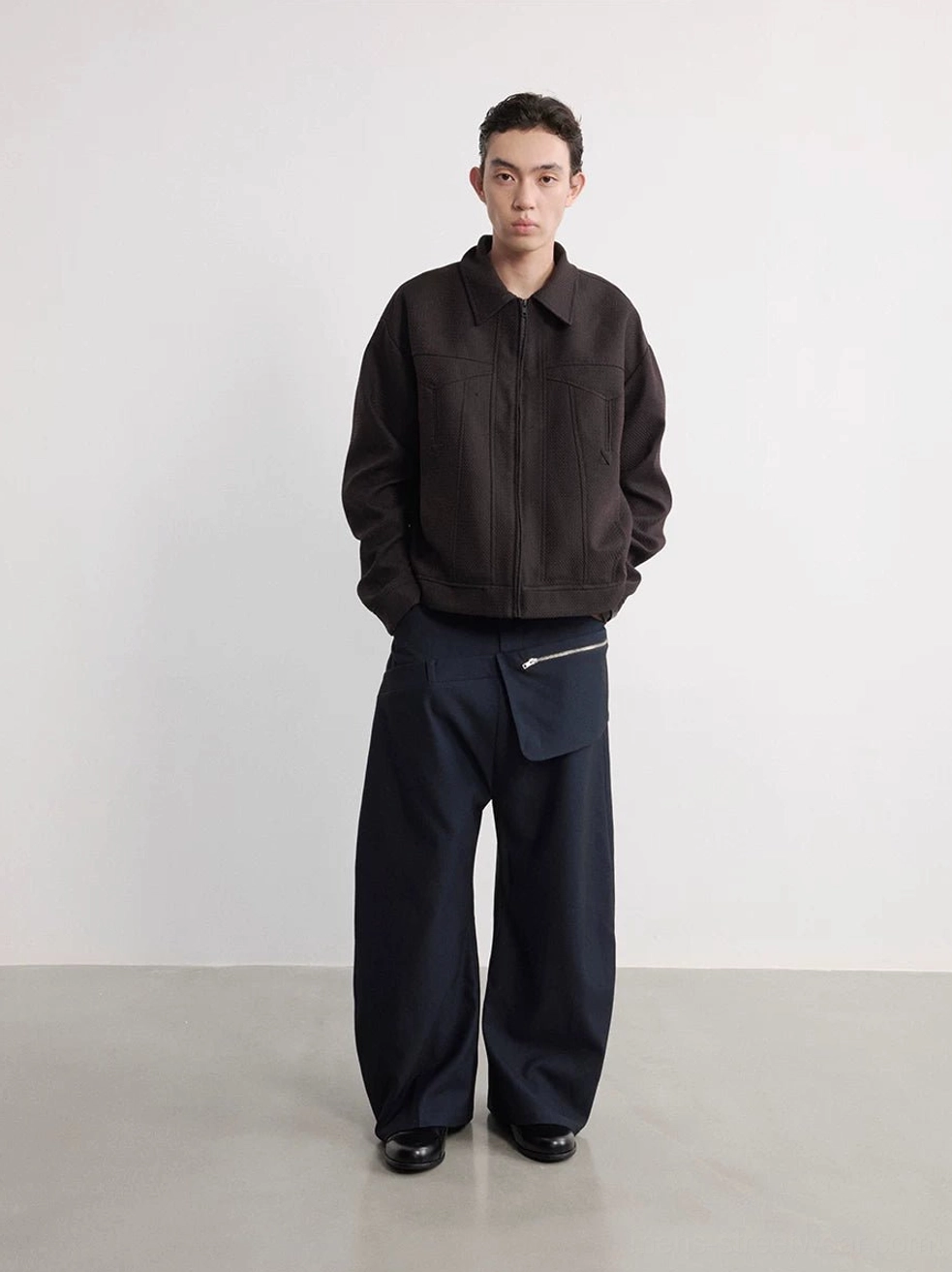 Full front view of men's navy detachable zipper pouch wide-leg trousers in a minimalist white studio