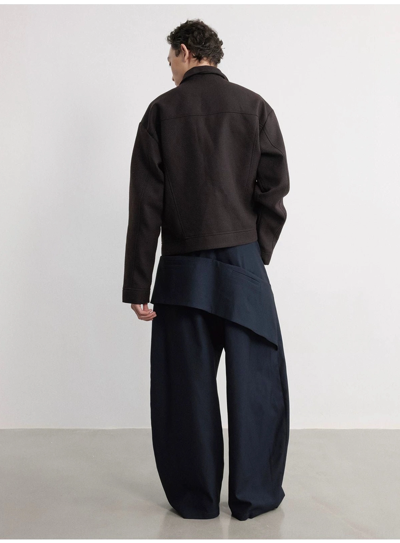 Full rear view of navy blue black wide-leg trousers with layered detachable hip pouch and relaxed oversized fit
