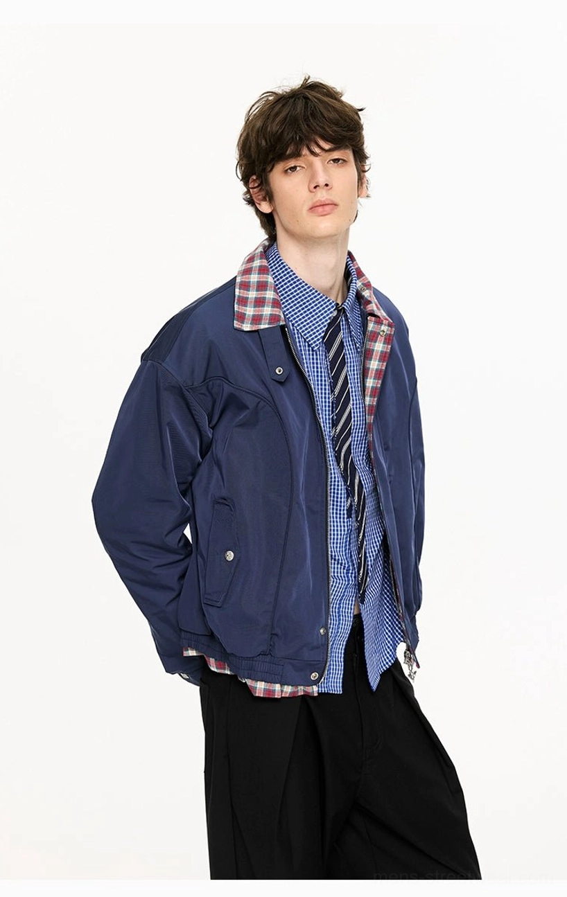 Navy blue cropped Harrington jacket three-quarter side view with exposed plaid collar lining and relaxed streetwear silhouette