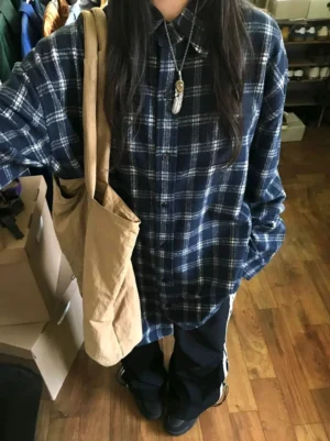 Navy plaid oversized flannel shirt worn open with a relaxed Korean streetwear fit and khaki canvas tote bag