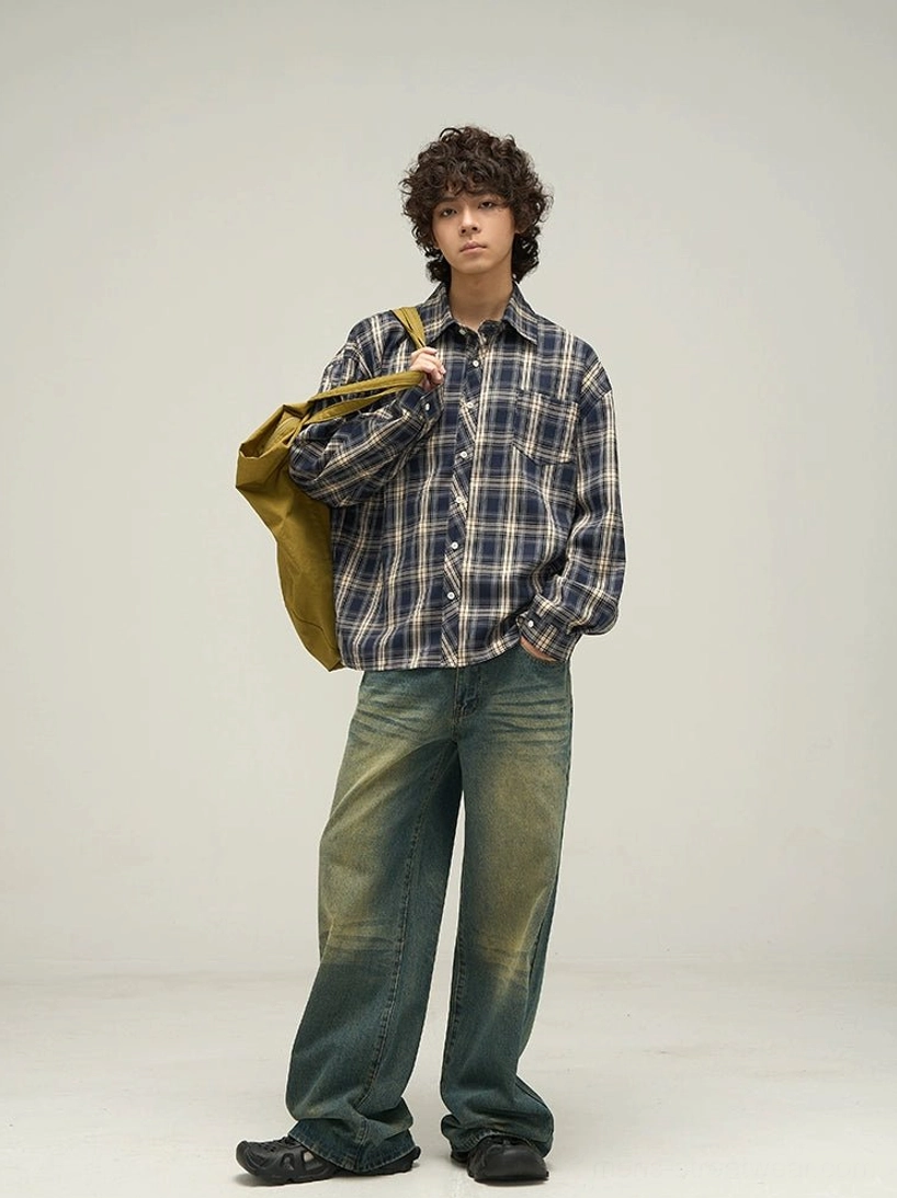 Three-quarter front view of navy plaid oversized long sleeve shirt styled with wide-leg jeans and canvas tote bag