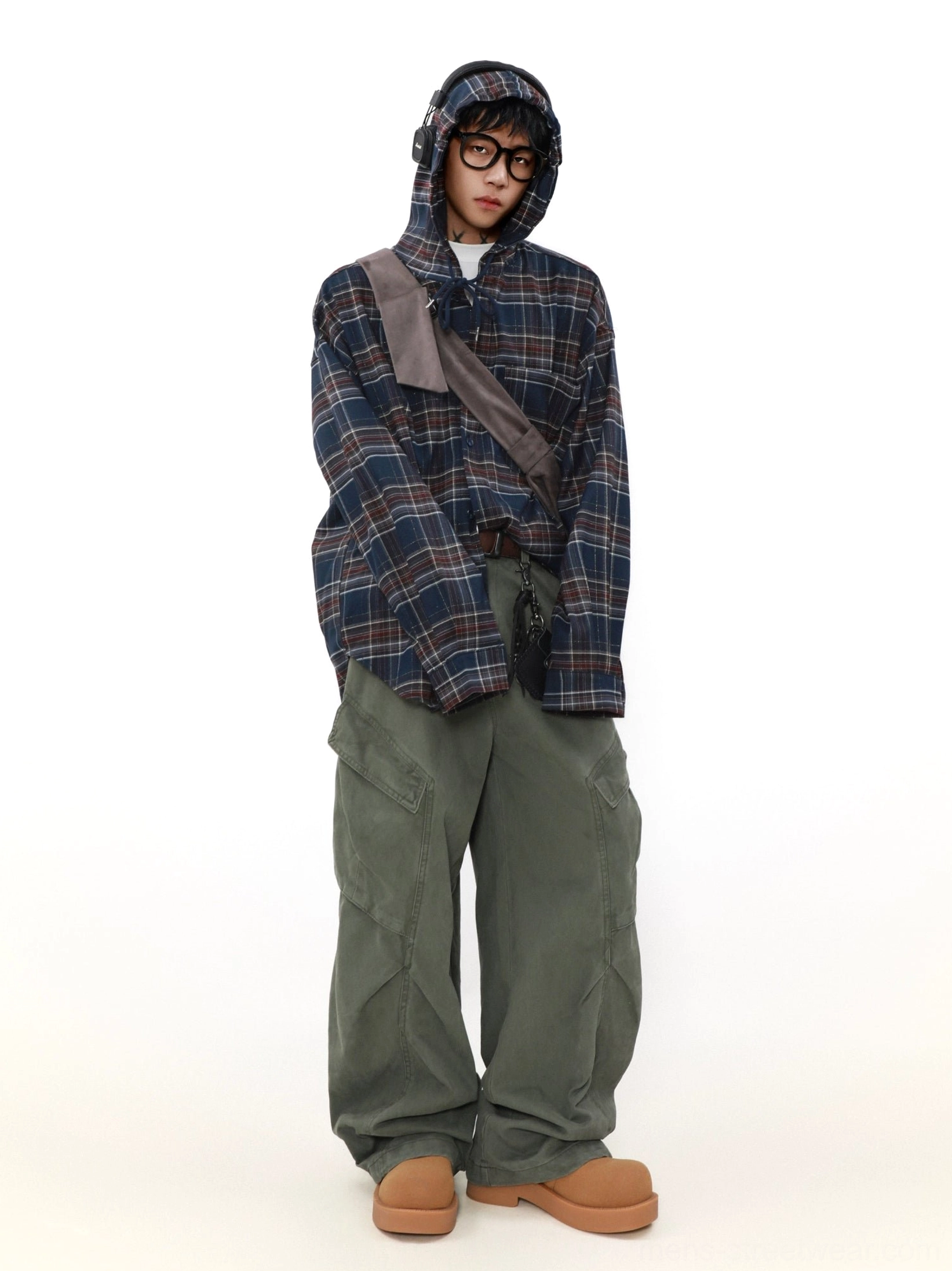 Full body male streetwear outfit featuring a navy red plaid hooded shirt cargo pants and tan casual boots