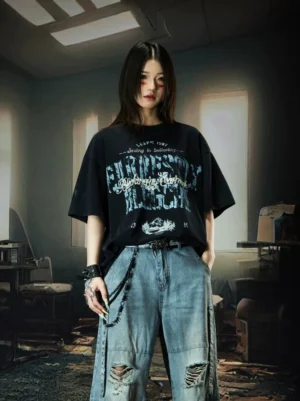Front view of black Nebula Varsity oversized graphic T-shirt with distressed blue typography print styled with ripped light wash wide leg jeans