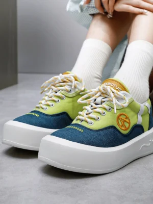 Female model wearing neon colorblock canvas platform sneakers with white crew socks and chunky platform soles