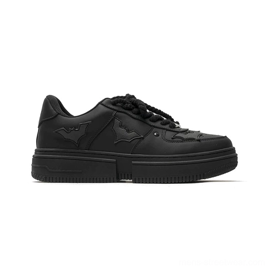 Side view of black Nightwing bat crest platform streetwear sneakers with matte PU upper, rope laces, and chunky rubber sole