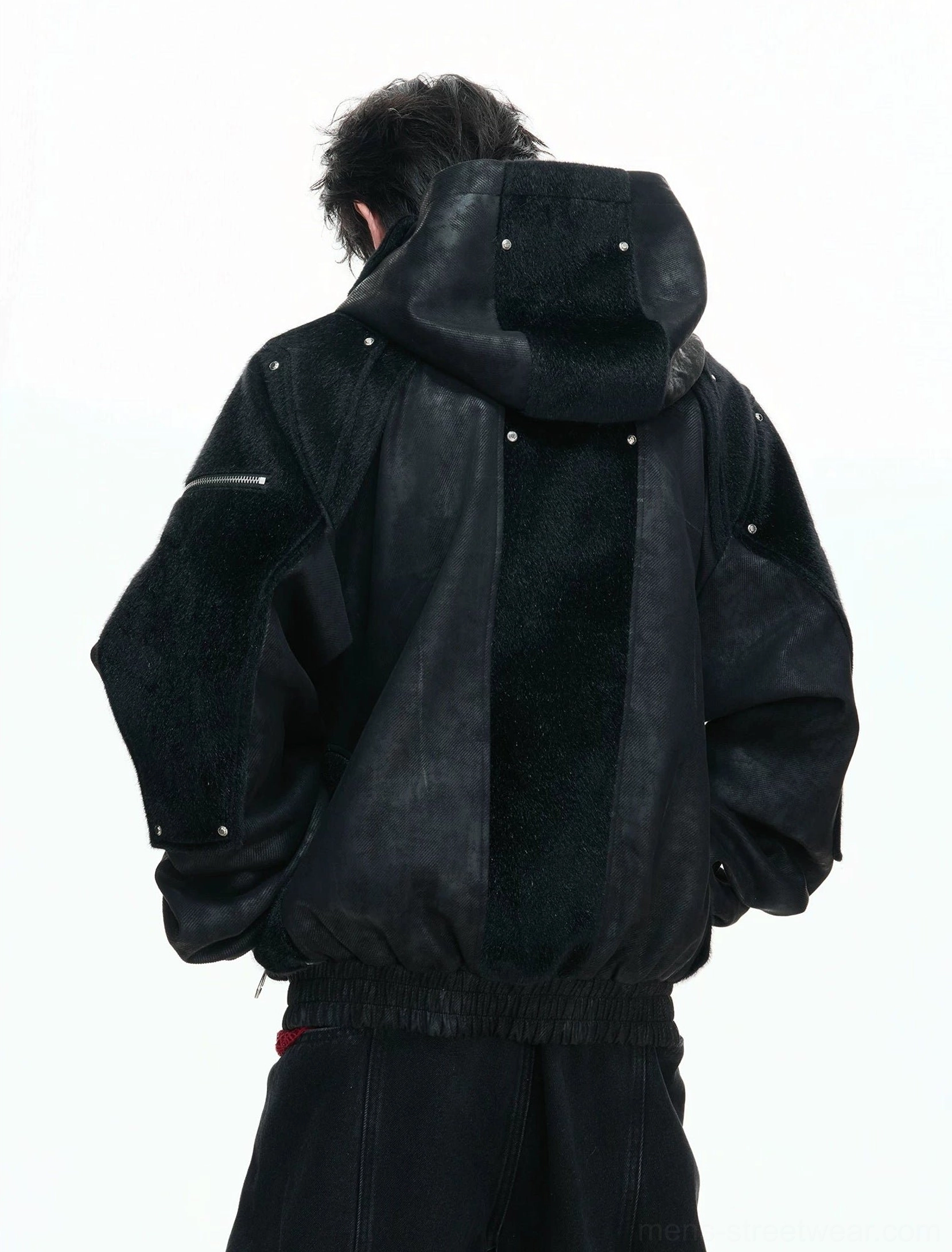 Back view of black armored streetwear hoodie jacket with fleece back panel rivet details and ribbed hem