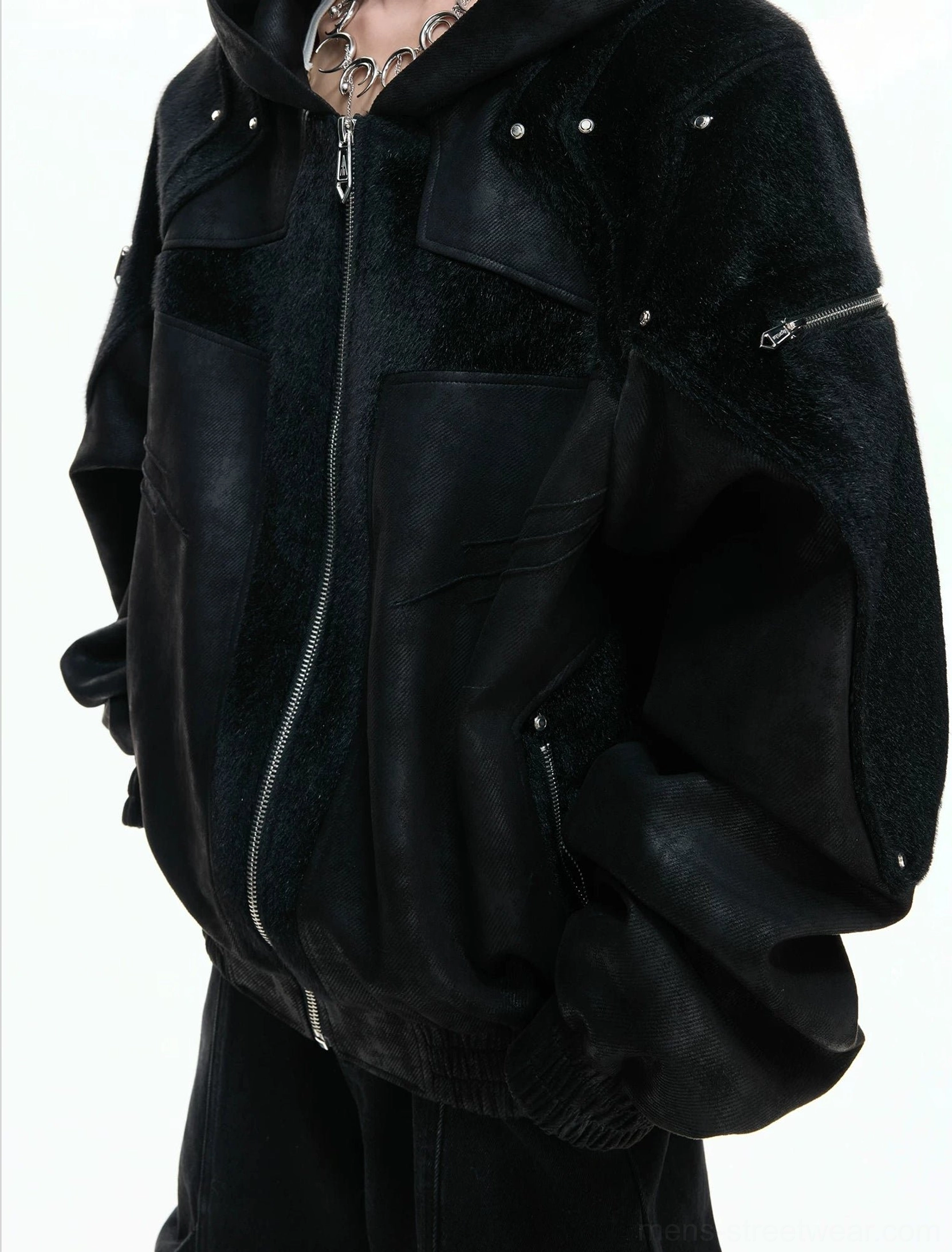 Close-up of black faux leather armored hoodie jacket showing metal zipper riveted panels side pocket and sleeve zipper