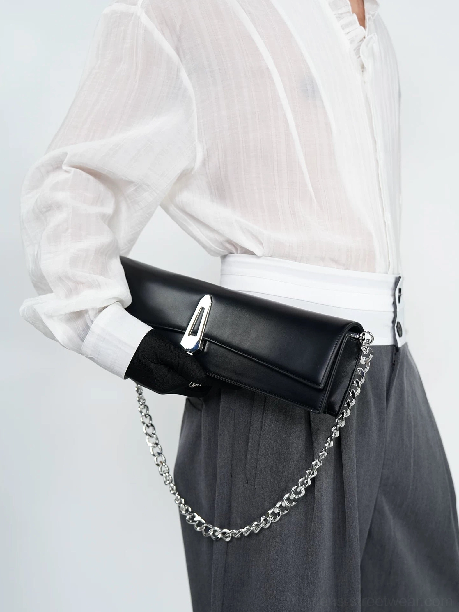 Obsidian black chain shoulder clutch bag close-up worn at the hip with silver curb chain and metal clasp