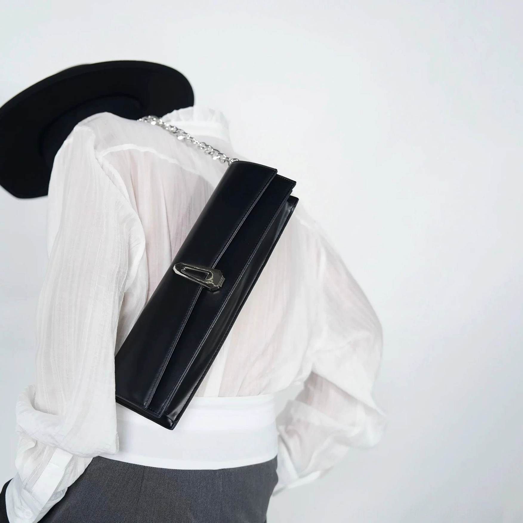 Obsidian black chain shoulder clutch bag back close-up showing structured PU body silver clasp and shoulder styling
