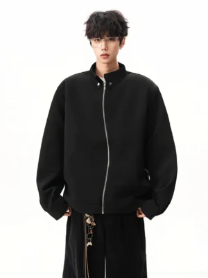 Front view of black minimalist stand collar zip jacket fully zipped with silver hardware and relaxed dropped shoulder fit