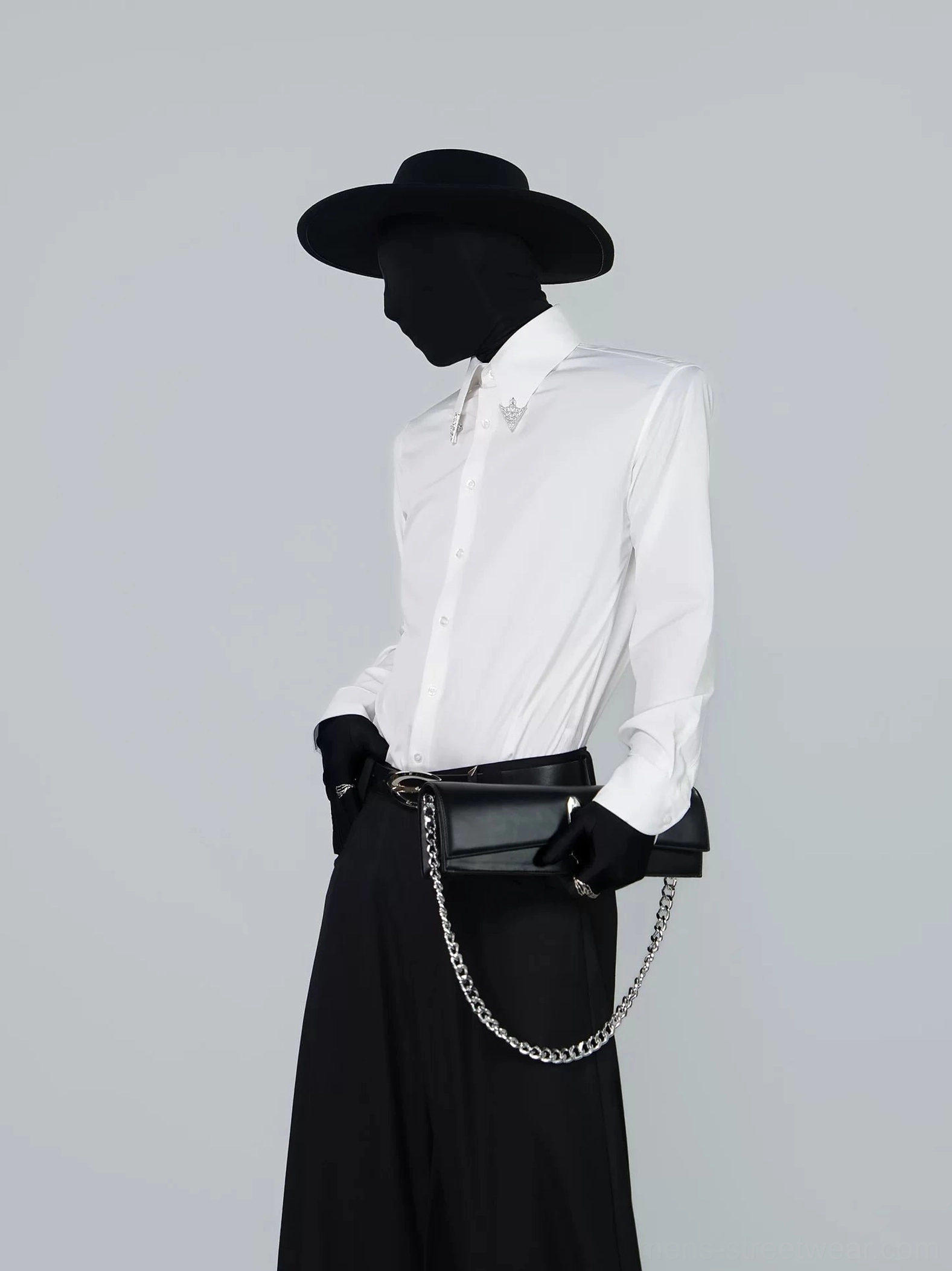 Black PU chain shoulder clutch bag with silver hardware worn at hip in avant-garde Korean streetwear outfit